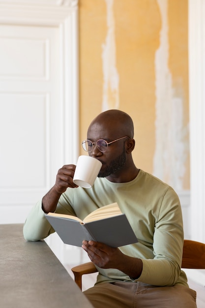 室内で読書するミディアムショットの男性