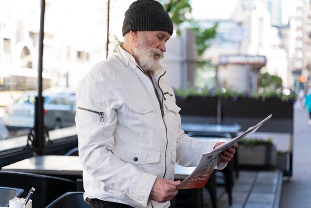 Мужчина среднего кадра читает газету