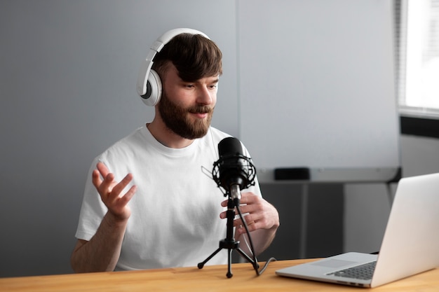 Medium shot man recording podcast indoors