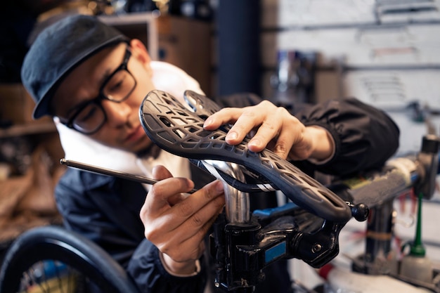 店内で自転車を修理するミディアムショットの男