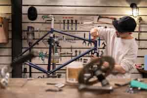 Бесплатное фото Человек среднего кадра, ремонтирующий велосипед