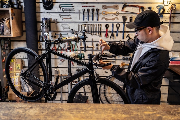 Бесплатное фото Человек среднего кадра, ремонтирующий велосипед