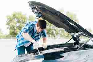 Free photo medium shot of man repairing engine