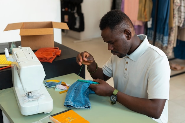 Medium shot man repairing fashion goods