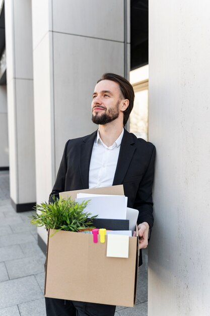 Medium shot man resigning with cardboard box