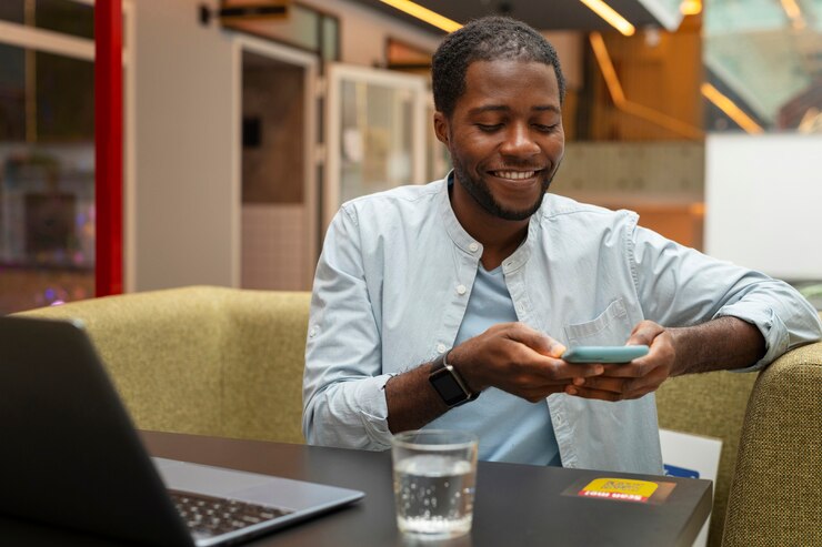 Free Photo medium shot man in restaurant with smartphone