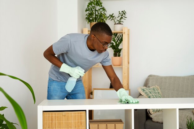 Medium shot man servant cleaning table