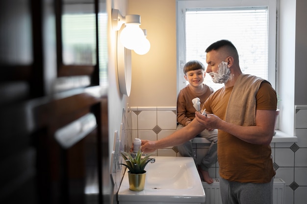 Medium shot man shaving at home