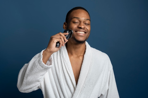 Free photo medium shot man shaving