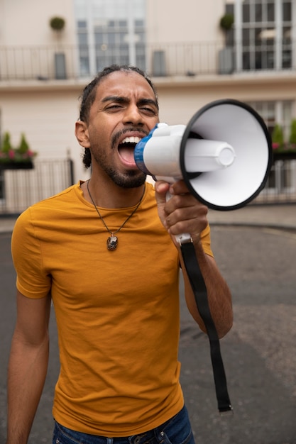 Free photo medium shot man shouting into a megaphone