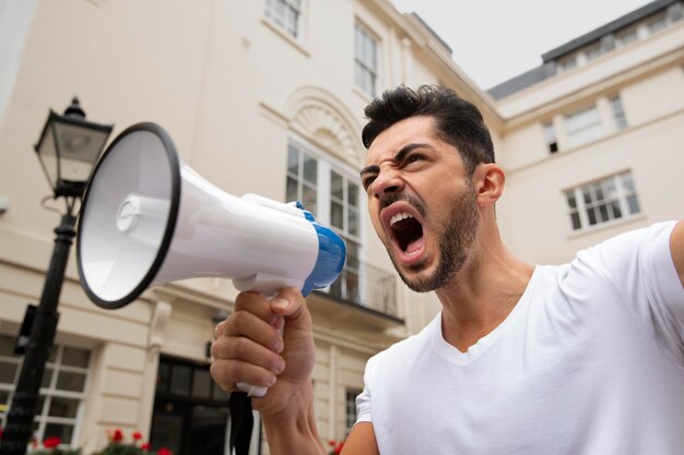 Medium shot man shouting into a megaphone