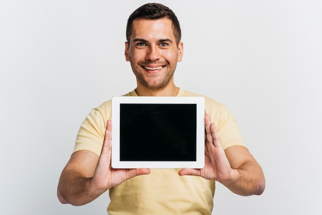 Medium shot man showing a tablet mock-up