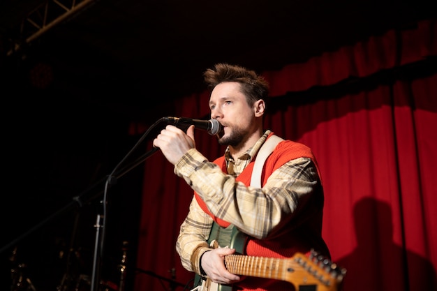 Free photo medium shot man singing with microphone