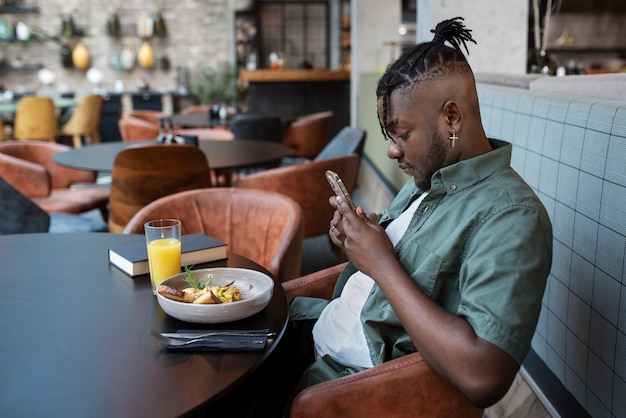 Foto gratuita uomo del colpo medio che si siede nella caffetteria