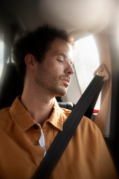 Free photo medium shot man sleeping in car