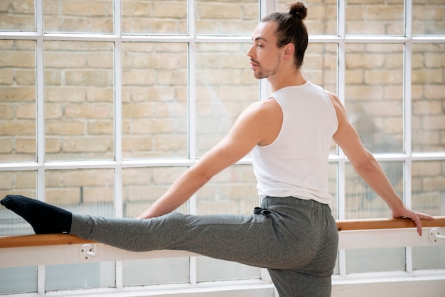 Free photo medium shot man stretching leg