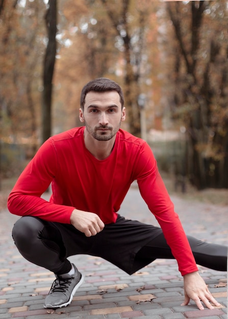 Free photo medium shot man stretching outdoors