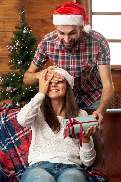 Medium shot man surprising woman with gift