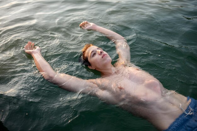 Medium shot man swimming in sea