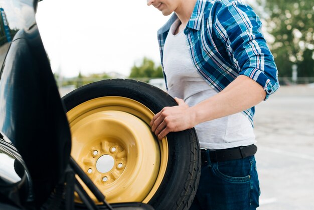 Medium shot of man taking out spare tire