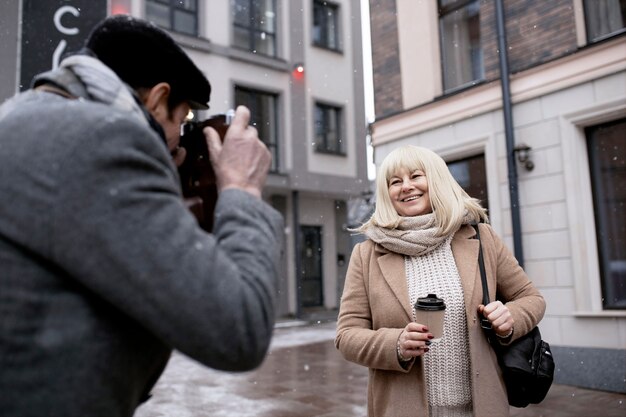 Medium shot man taking photos of woman