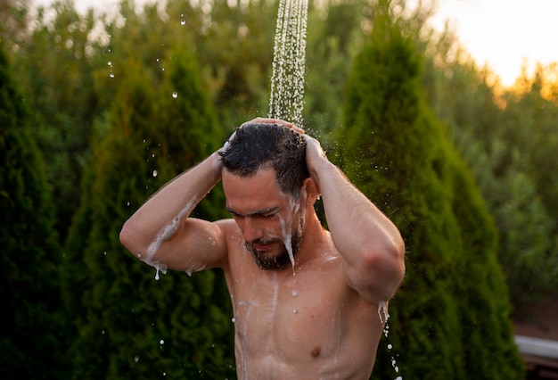 Free photo medium shot man taking shower