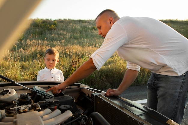 Medium shot man teaching kid about car