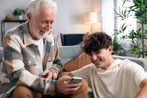 Medium shot man and teen with smartphone