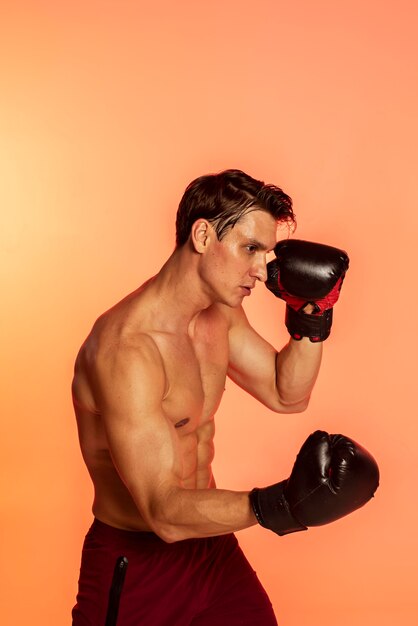 Medium shot man training with boxing gloves