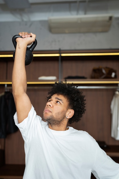 Foto gratuita allenamento uomo a tiro medio con kettlebell