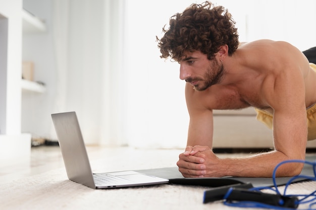 Foto gratuita uomo di tiro medio che si allena con il laptop