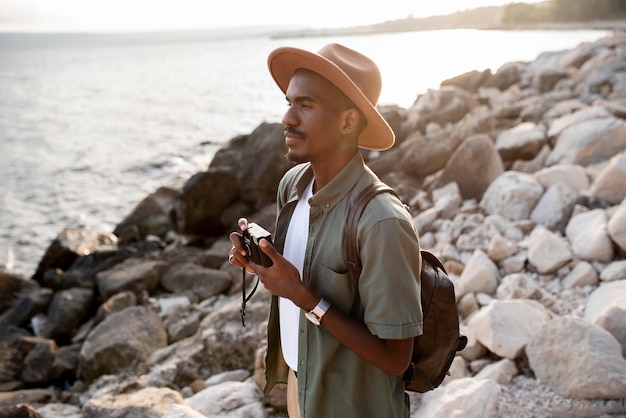 Medium shot man traveling with camera