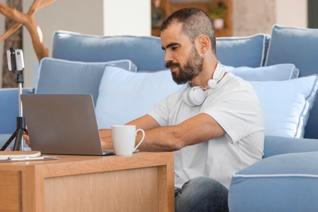 Uomo del colpo medio che digita sul computer portatile