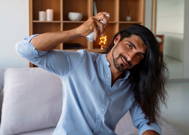 Medium shot man using dry shampoo  at home