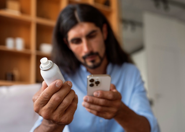 Foto gratuita uomo di tiro medio che usa shampoo a secco a casa