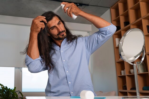 Medium shot man using dry shampoo  at home