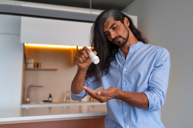 Medium shot man using dry shampoo  at home