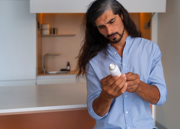 Medium shot man using dry shampoo  at home