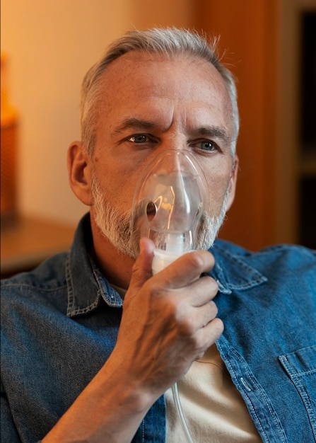 Medium shot man using nebulizer