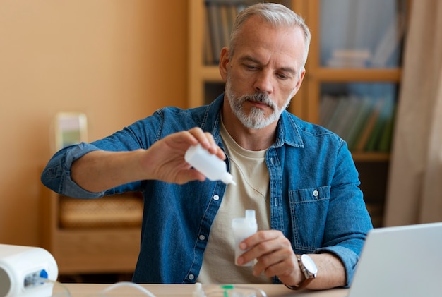 Medium shot man using nebulizer