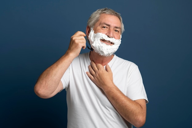 Мужчина среднего роста использует крем для бритья