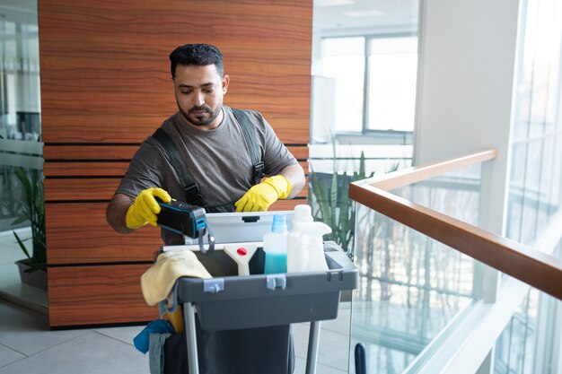 Medium shot man walking with cleaning cart