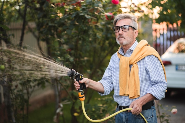 Medium shot man watering plants