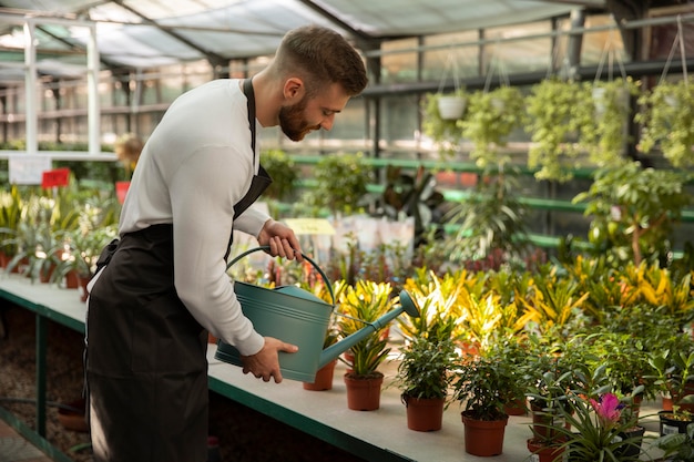 無料写真 ミディアムショットの男が植物に水をまく