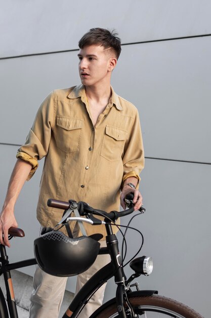 バイクとヘルメットを持つミディアムショットの男
