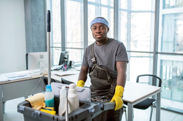 Medium shot man with cleaning cart