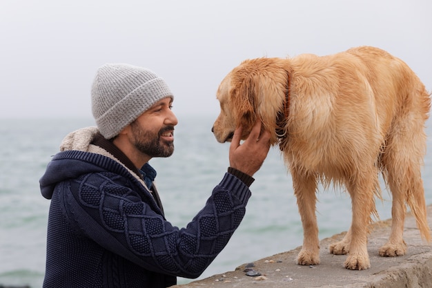 無料写真 海辺で犬とミディアムショットの男