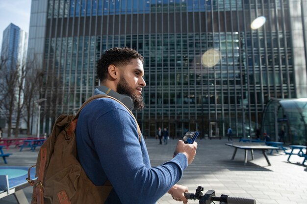 Medium shot man with electric scooter in city