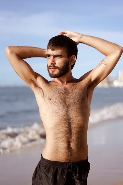 Free photo medium shot man with hairy chest at seaside