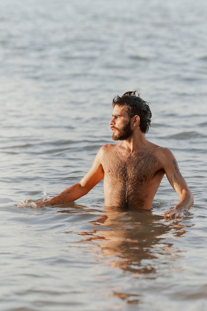 Free photo medium shot man with hairy chest at seaside